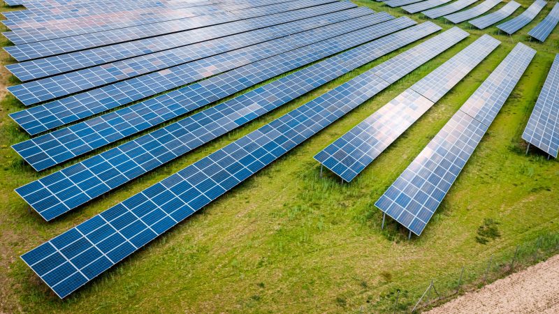 Big and blue photovoltaic farm as a renewable energy source. Pure energy in the countryside.